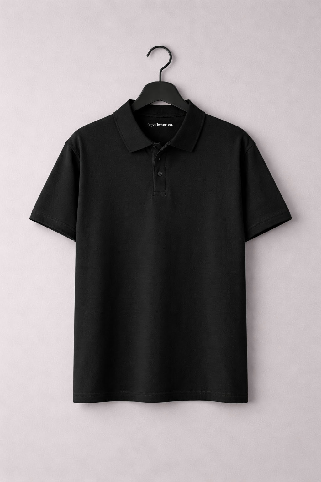 Black polo t-shirt hanging on a hanger with a classic collar and button placket