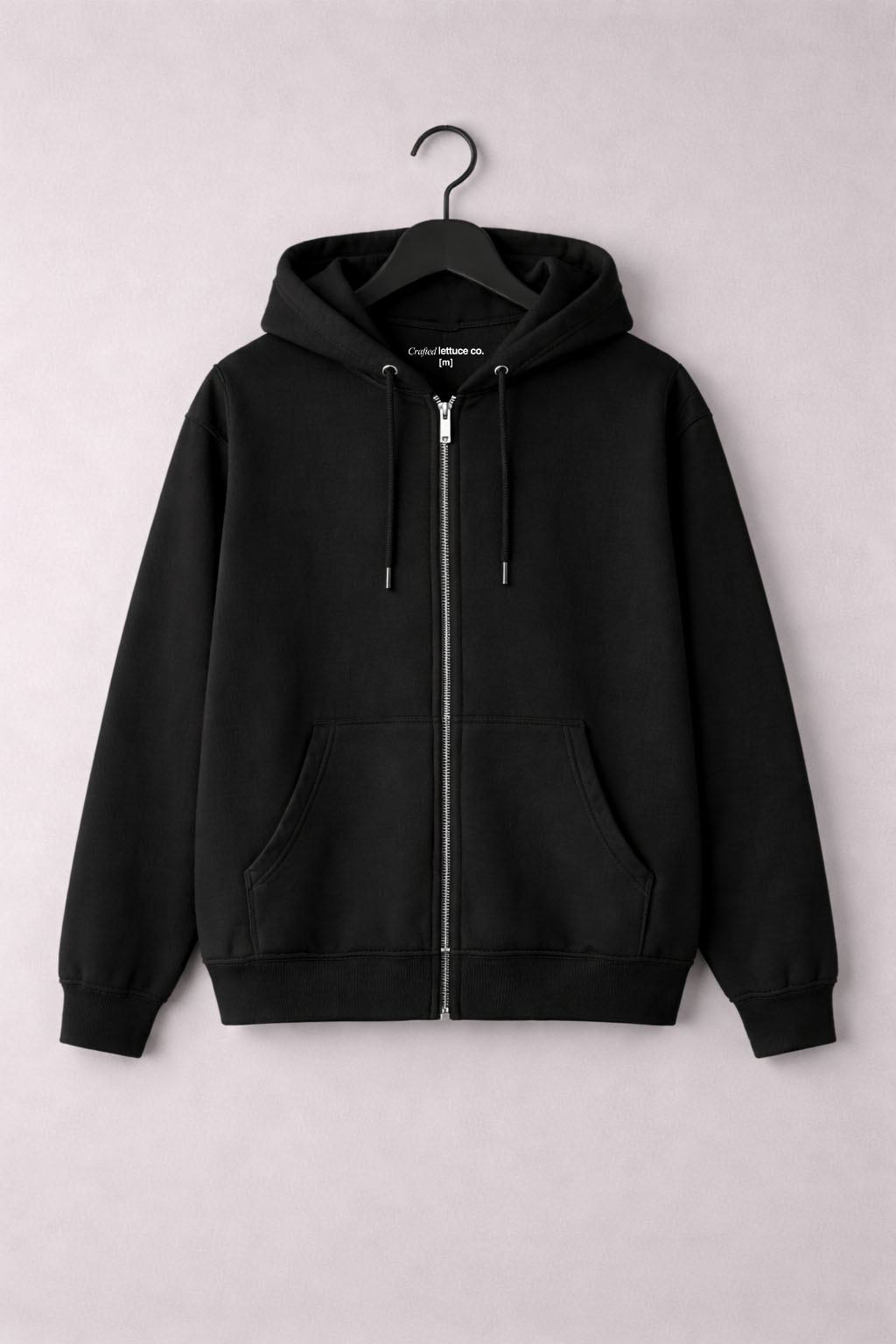 Black zipper hoodie hanging on a hanger with a clean minimal background